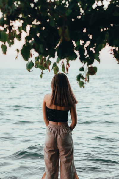 woman in black and white stripe dress standing in front of body of water during daytime